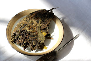 compressed yellow flakes on a gaiwan lid